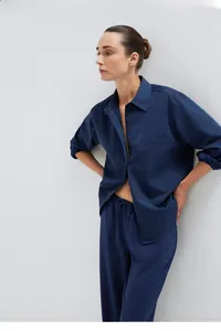 Detailed close-up of dark blue long-sleeved shirt featuring chest pocket and natural fabric
