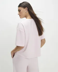 Detail view of pink women's two-piece set featuring short sleeves and side slit top
