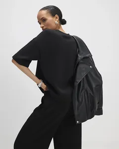 Detail of black two-piece casual set featuring a textured leather jacket with silver zippers