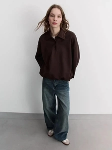 Women's brown long sleeve polo sweatshirt with dark blue wide leg jeans and sneakers