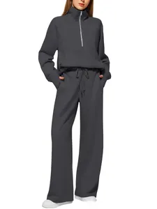 Detail of dark grey two-piece tracksuit featuring 1/4 zip hoodie and drawstring wide-leg pants
