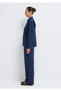 Side view of dark blue minimalist shirt and wide-leg trousers set in studio setting