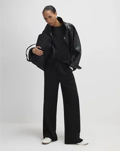 Full body shot of a minimalist black two-piece set featuring wide-leg drawstring trousers