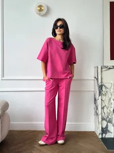 Close-up of vibrant rose pink two-piece set featuring drop shoulder tee and wide-leg trousers
