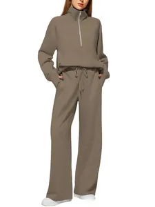 Close-up of women's taupe track suit with half-zip hoodie and straight-leg pants