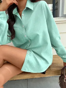 Dettaglio camicia verde menta a maniche lunghe con tasca quadrata e bottoni bianchi