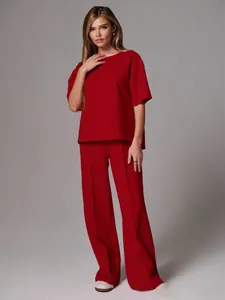 Detail of red two-piece set featuring loose crew neck top and high-waist wide-leg trousers