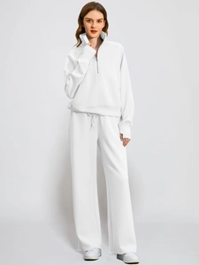 Women's white two-piece lounge set featuring half-zip sweatshirt and wide-leg sweatpants