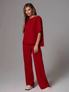 Detail view of stylish red two-piece set featuring short sleeve top and wide leg trousers