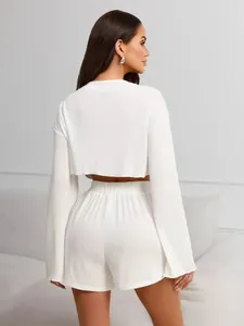 Back view of a white knit two-piece lounge set with long-sleeve crop top and elastic shorts