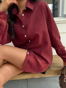 Dettaglio camicia in velluto a coste bordeaux con bottoni bianchi e taschino sul petto