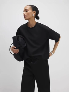 Women's two-piece black lounge set featuring short sleeve top and drawstring pants