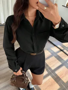 Dettaglio di un set camicia nera a maniche lunghe con tasca e pantaloncini a vita alta