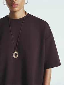Vintage gold oval pendant necklace and hoop earrings set on brown shirt outfit