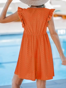 Détail d'une robe orange à broderie anglaise avec manches à volants et vue arrière de vacances