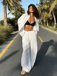 Close-up of natural cotton linen texture on a white oversized shirt and loose pants set