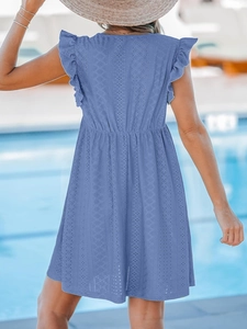 Vue de dos d'une robe d'été bleue avec dentelle ajourée et épaules à volants au bord de l'eau