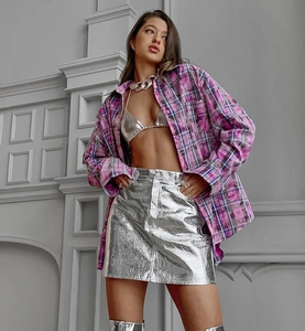 Détail de mode urbaine avec chemise à carreaux, haut de bikini argenté et mini-jupe