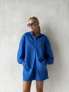 Detail of royal blue linen set featuring a long sleeve button shirt and high waist shorts
