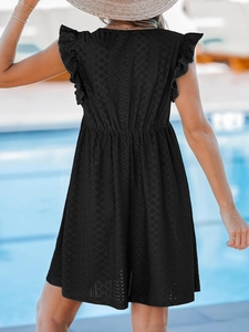 Détail de la robe en dentelle noire avec manches à volants et broderie ajourée