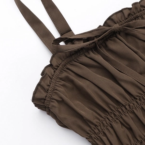 Detail of adjustable straps and smocking craft on a brown mini summer dress