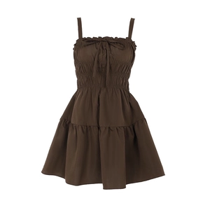 Detail of smocked waist and ruffled neckline on a brown mini sundress with bow tie