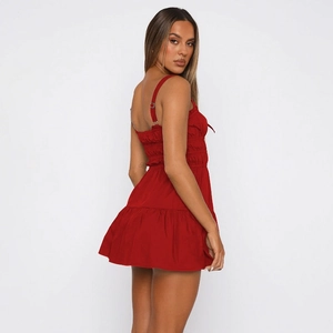Detail view of the red mini dress with smocked elastic back and ruffled hemline