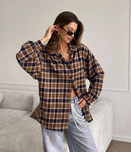 Detailed close-up of oversized brown plaid flannel shirt with drop shoulder design