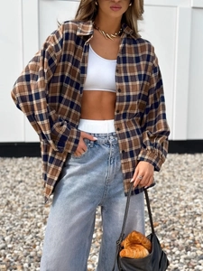 Close-up of vintage plaid shirt featuring brown and navy checkered pattern and soft fabric
