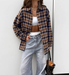 Detail of oversized plaid shirt in brown and navy blue flannel with soft texture