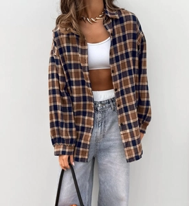 Oversized retro plaid shirt styled as an open jacket over a white crop top and jeans