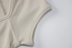 Dettaglio ravvicinato della trama a costine sottili e delle cuciture pulite dell'abito beige