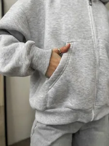 Close-up of light grey zip-up hoodie featuring ribbed cuffs and soft cotton knit texture