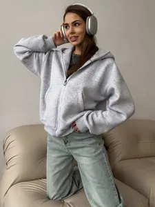 Detail of light gray zip-up hoodie featuring relaxed drop shoulders and soft texture