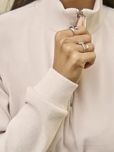 Close-up of a silver minimalist ring and yellow square diamond ring set on a hand