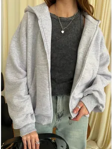 Detail of light gray zip-up hoodie featuring loose fit with casual layered styling