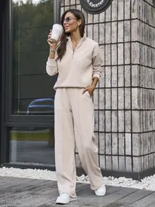 Close-up of women's beige half-zip tracksuit set with stand collar and wide-leg trousers