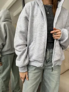 Detail view of oversized grey zip-up hoodie with metal zipper and soft ribbed cuffs