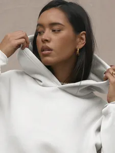 Close-up of a white oversized hoodie featuring soft knitted texture and drop shoulder design