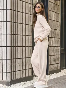 Detail view of beige ribbed lounge set featuring half-zip sweatshirt and wide-leg trousers