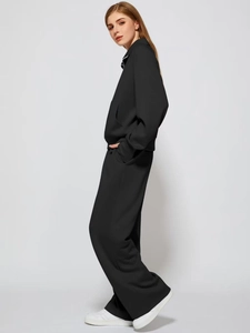 Full-body profile of a black two-piece tracksuit with long-sleeved top and wide-leg pants