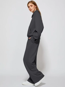 Detail view of charcoal grey two-piece tracksuit with stand collar and wide-leg trousers