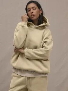 Detail of oversized beige fleece hoodie set showing ribbed cuffs and drawstring waist