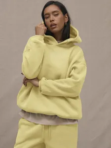 Detail of lemon yellow oversized hoodie and drawstring jogger set with a soft cotton texture