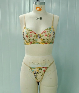 Detail view of floral embroidery on beige sheer lace bra with underwire support