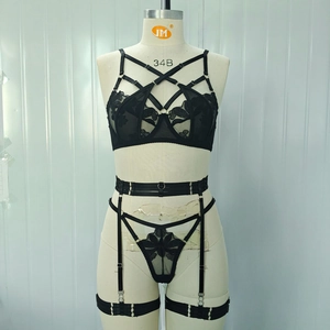 Three-piece black lace lingerie set with embroidery, strappy bra, and garter belt