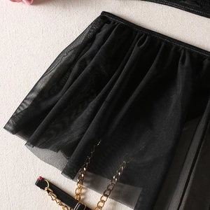 Detailed macro view of black pleated sheer mesh with golden metal chains and adjustable straps