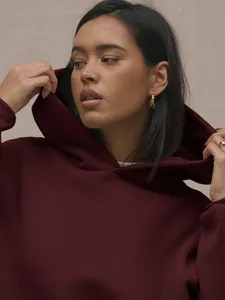 Detailed texture of heavy-weight burgundy knit fabric on a stylish oversized hoodie