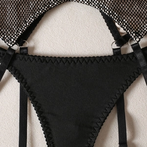 Détail de lingerie résille noire avec bords ondulés et boucles de réglage en métal argenté
