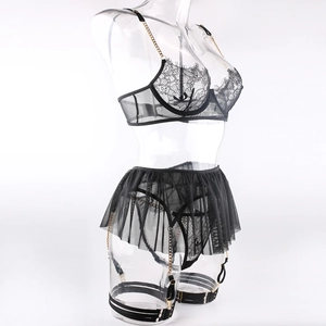 Detailed view of black lace lingerie set with gold chain straps and sheer mesh skirt detail